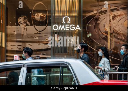 Hong Kong, Cina. 16th Mar 2022. Gli acquirenti che indossano maschere chirurgiche camminano presso un negozio Omega nel quartiere Centrale degli Affari di Hong Kong. Secondo l'analisi economica del governo di Hong Kong, il settore della vendita al dettaglio sta affrontando una pressione immensa nel breve termine, con le pandemiche e le relative misure di distanziamento sociale che creano sfide per un rilancio. (Foto di ben Marans/SOPA Images/Sipa USA) Credit: Sipa USA/Alamy Live News Foto Stock