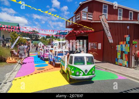 Bambini che cavalcano su un 'Kombi Ride', un treno in miniatura fatto per assomiglia ai furgoni VW Kombi, nel villaggio storico di Tauranga, Tauranga, Nuova Zelanda Foto Stock