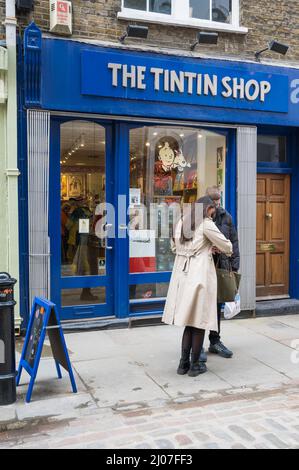 Uomo e donna si trovano fuori dal negozio Tintin a Floral Street, Covent Garden, Londra, Inghilterra, Regno Unito Foto Stock