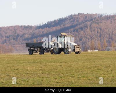 BIELSKO-BIALA, POLONIA il 2020 APRILE: Trattore con rimorchio sul campo d'aviazione sportiva nella città europea, cielo blu chiaro in calda giornata di sole primaverile. Foto Stock