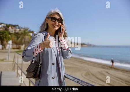 Foto di una donna affascinante con telefono all'aperto Foto Stock