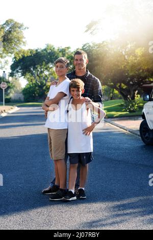 Papà e i suoi due figli cool. Ritratto di un padre in piedi con i suoi due figli piccoli fuori. Foto Stock