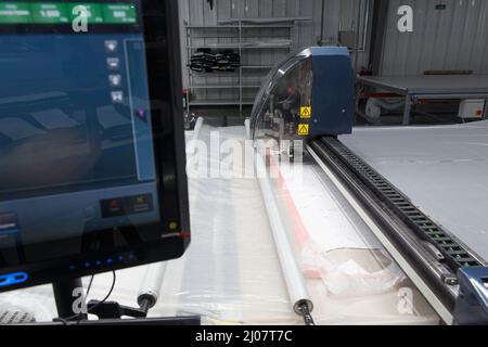 Fabbrica di abbigliamento industriale, uno speciale tessuto da taglio laser taglia alcuni pezzi tessili. Concetto di: Macchina laser, lavoro in fabbrica, automatico cu Foto Stock
