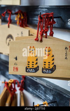 Tavole di preghiera giapponesi in legno o Ema 絵馬 appese ad un tempio di Kyoto, Giappone, che mostra la scrittura giapponese Foto Stock