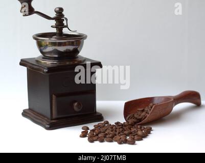 Chicchi di caffè su cucchiaio di legno e macinacaffè d'epoca Biji Kopi dan Penggiling Biji Kopi Kayu Vintage Foto Stock