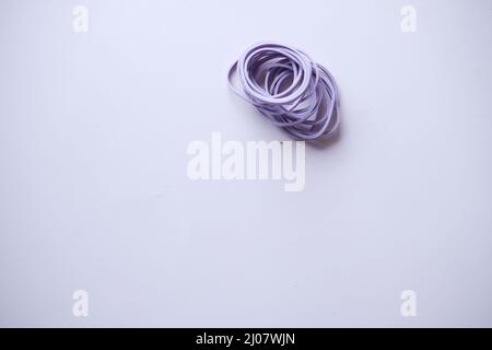 Bande in gomma di colore viola sul tavolo Foto Stock