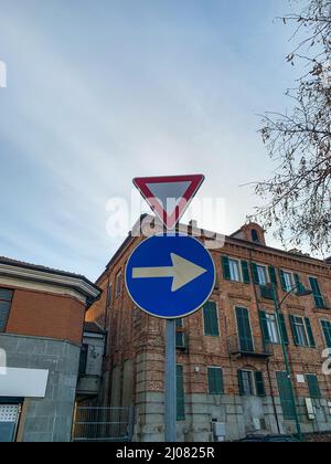 Colpo verticale di dare modo e girare a destra segnaletica stradale Foto Stock