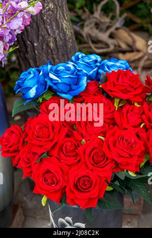 Un bouquet di fiori falsi di rose belle e rosse luminose Foto Stock