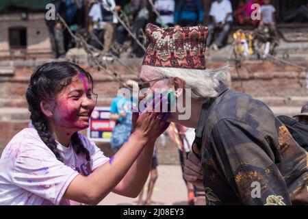 Lalitpur, Nepal. 17th Mar 2022. Una ragazza striscia polvere colorata su un turista durante la celebrazione di Holi, il festival dei colori, a Lalitpur, Nepal, 17 marzo 2022. Credit: Hari Maharjan/Xinhua/Alamy Live News Foto Stock