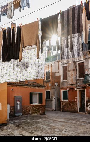 Lavanderia appeso fuori dalla tipica facciata veneziana, Italy.Narrow strada con edifici colorati e vestiti asciutti su corda, Venice.clean vestiti asciugando all'aperto Foto Stock
