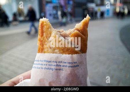 morso estratto dal rotolo di salsiccia di greggs sul movimento liverpool, inghilterra, regno unito Foto Stock