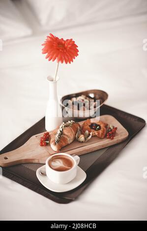 Prima colazione servita con croissant, dolci freschi e una tazza di caffè. Fotografie verticali. Foto Stock