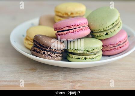 Piatto pieno di lamponi, limone, pistacchio e macaron al cioccolato Foto Stock