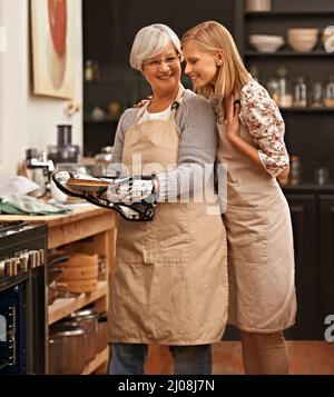 Odore incredibile Gran. Scatto di una bella giovane donna ammirando le sue grandmotheramp039s abilità di cottura. Foto Stock