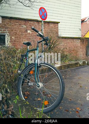 Bicicletta parcheggiata in una zona senza sosta. Immagine simbolica dei problemi di gestione dello spazio di parcheggio Foto Stock