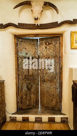 antica porta messicana coperta in milagros, piccolo fascino religioso metallo associato con miracoli e benedizioni da santi Foto Stock