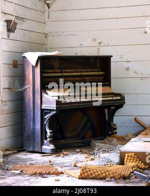 Antica chiesa abbandonata ha antico pianoforte coperto di polvere e di ciottoli. L'Avorio manca dalle chiavi e l'interno è aperto al deterioramento. Chiesa è vecchia w Foto Stock