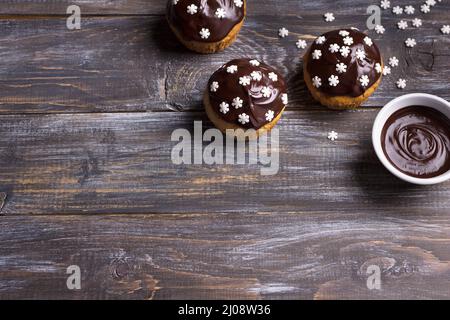 Muffin piccanti di zucca con noci, decorati con glassa al cioccolato e fiocchi di neve sotto l'albero di Natale su un tavolo di legno, spazio libero, selettivo Foto Stock