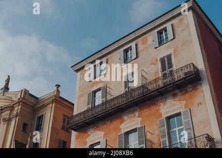 Facciata di un tradizionale edificio antico nella città vecchia di Nizza, Francia, in una giornata di sole, vista ad angolo basso contro il cielo blu. Foto Stock