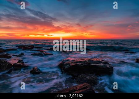 Il bel movimento offusca le onde del mare sulle rocce prima dell'alba Foto Stock