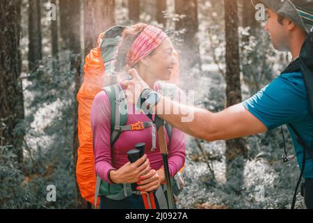 L'escursionista spruzza un aerosol per proteggere da insetti e zecche che aspirano sangue, portatori di malattie pericolose e parassiti. Sul sentiero nazionale Foto Stock
