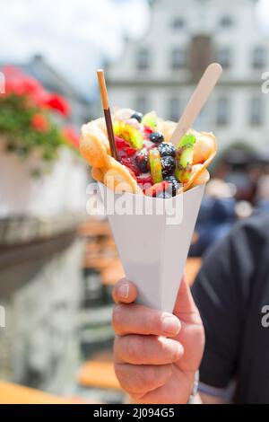 Nel centro storico (Brilon, Germania) è giorno di cheat. Un uomo può contenere fino un sacchetto di carta con bolla di cialde con frutta. La borsa offre spazio per la vostra cr Foto Stock