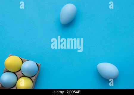 Carta da parati di Pasqua. Composizione semplicemente pasquale con uova blu e gialle. Spazio di copia. Foto Stock