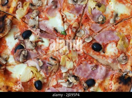 Pizza capricciosa. Pizza con prosciutto, olive, funghi e carciofi. Foto Stock