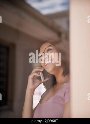 Connessione con i clienti dalla comodità della sua casa. Scatto corto di una giovane donna attraente su una chiamata a casa. Foto Stock