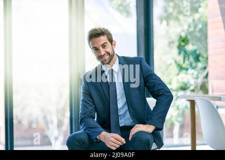 Impegnati nella vita aziendale. Scatto di un bel giovane uomo d'affari nel suo ufficio. Foto Stock