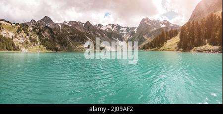 Un paesaggio bellissimo e suggestivo con un idilliaco lago di montagna durante un tramonto colorato nella natura selvaggia Foto Stock