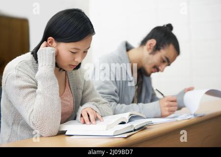 Questa prova potrebbe cambiare la loro vita per il peggio o per il meglio.... Immagine di due studenti seduti in una sala conferenze e studiando per gli esami. Foto Stock
