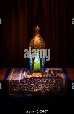 Una lanterna ornamentale dorata del Ramadan con rosario. Uno sfondo islamico festivo. Foto Stock