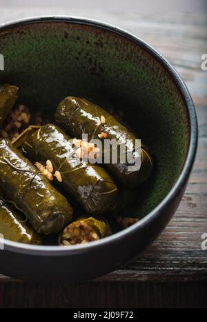 Foglie di vite ripiene, o Dolmades, in una ciotola. Primo piano. Foglie di vite con riso farcito. Cucina tradizionale del Medio Oriente. Foto Stock