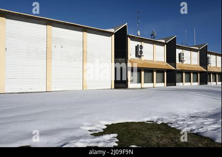 abbandonato edificio non residenziale con parabola satellitare sul tetto in inverno, deadpan fotografia Foto Stock