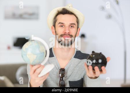 uomo che mostra il mondo e i suoi risparmi Foto Stock