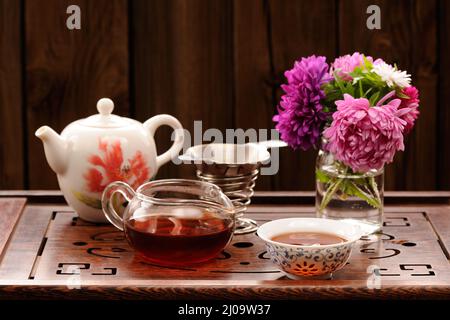 Bouquet di cerotti viola e rosa e teaware per la cerimonia cinese del tè orizzontale Foto Stock