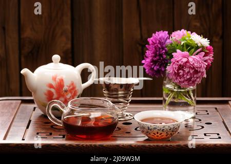 Bouquet di cerotti viola e rosa e teaware per la cerimonia cinese del tè orizzontale Foto Stock