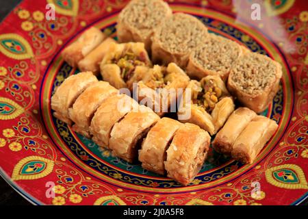 Dolci Turchi, Chiudi Mini Baklava dolci tradizionali su piatto rosso marocchino Foto Stock