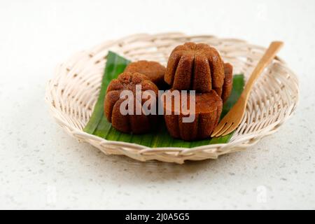 Torta al caramello al vapore Bolu Sakura, realizzata in caramello con pastella di uova, zucchero, farina e burro. Servito su piatto di bambù con foglia di Banana Foto Stock