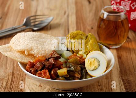 Lontong Cap Go Meh, Sayur lontong indonesiano con influenza cinese peranakana. Su tavola di legno Foto Stock