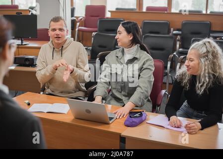 L'insegnante e gli studenti comunicano nella lingua dei segni in classe. Non udenti e non udenti Foto Stock