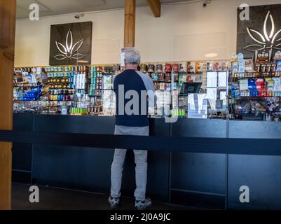 Woodinville, WA USA - circa Febbraio 2022: Vista di un uomo anziano che acquista marijuana all'interno del negozio di erbacce di Leaf superiore. Foto Stock