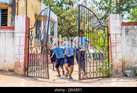 I bambini che escono dalla scuola aprendo la porta dopo la campana - concetto di istruzione, libertà, felicità e crescita infantile. Foto Stock