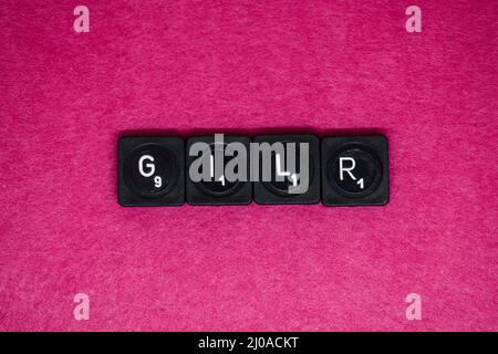 Vista dall'alto delle mattonelle scrabble nere che dicono la ragazza sullo sfondo rosa Foto Stock