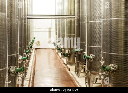 Produzione di vino su larga scala. Shot dei recipienti di fermentazione all'interno di una vinificazione. Foto Stock