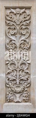 Pannello intagliato in stile art nouveau sull'esterno di un edificio. Pannello decorativo ornato con foglie e fiori. Design tradizionale in pietra calcarea. Foto Stock