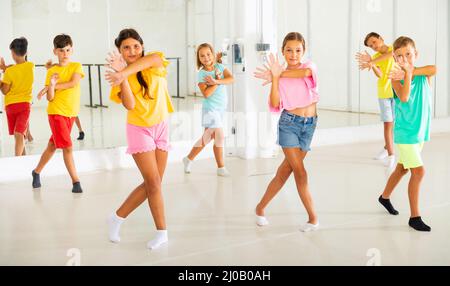 I bambini che esercitano la danza moderna si muovono insieme Foto Stock