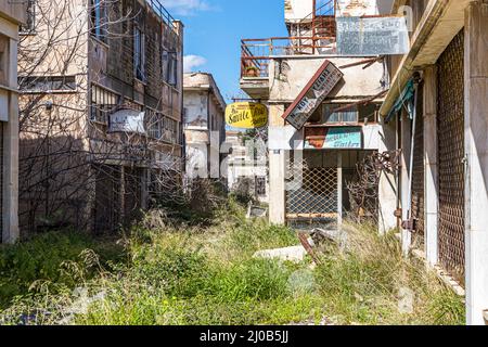 Il distretto di Varosha (Kapalı Maraş) a Famagosta (Cipro) fu tra il 1970 e il 1974 una delle destinazioni turistiche più popolari al mondo. I suoi abitanti greco-ciprioti fuggirono durante l'invasione turca di Cipro nel 1974, quando la città di Famagosta passò sotto il controllo turco. Da allora è rimasto abbandonato e gli edifici sono decaduti. La maggior parte degli abitanti originari di Varosha (e dei loro diretti discendenti) vive ora a sud della zona cuscinetto delle Nazioni Unite di Cipro. Queste famiglie sono ancora i legittimi proprietari di proprietà a Varosha, ma mentre la città è combattuta, non possono rivendicarla. E poi, molti Foto Stock