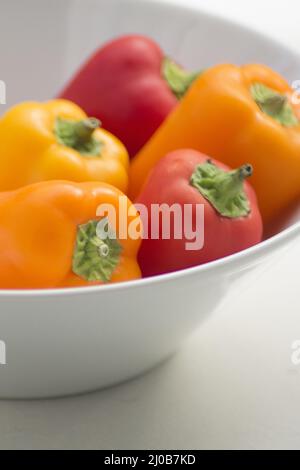 Peperoni freschi crudi nel piatto Foto Stock